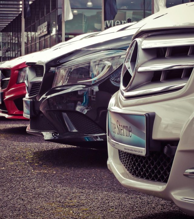 Luxury cars lined up at an outdoor dealership, showcasing sleek designs.