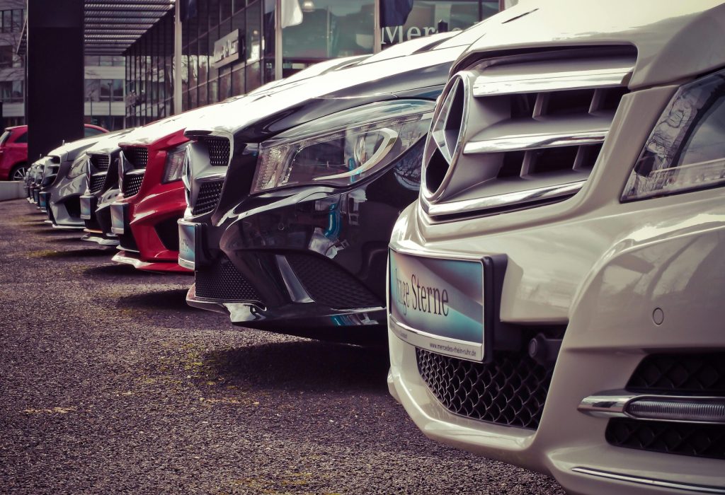Luxury cars lined up at an outdoor dealership, showcasing sleek designs.