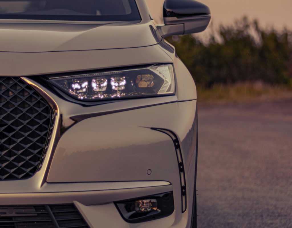 A close-up shot of a gray car at twilight on an open road, showcasing modern design.