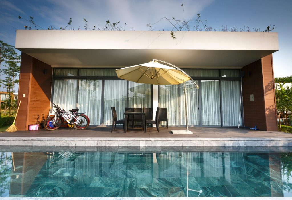 Contemporary outdoor patio with chairs and poolside view, perfect for luxury relaxation.