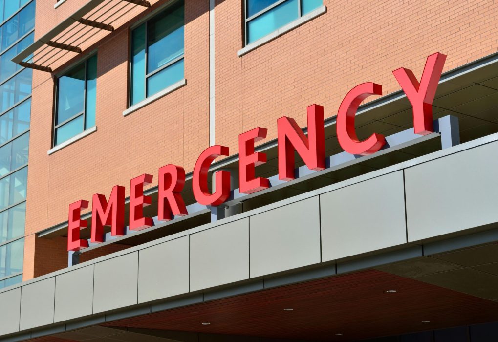 Close-up of a modern hospital emergency room entrance with prominent red letters.