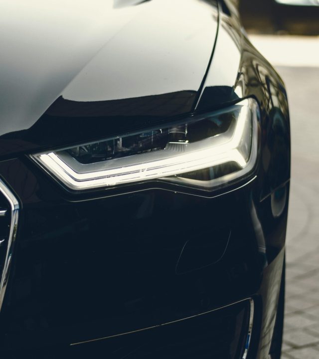 A sleek, modern luxury car showcasing its chrome detailing and LED headlights on a city street.