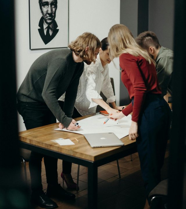 Group of diverse professionals brainstorming ideas in a stylish modern office space.