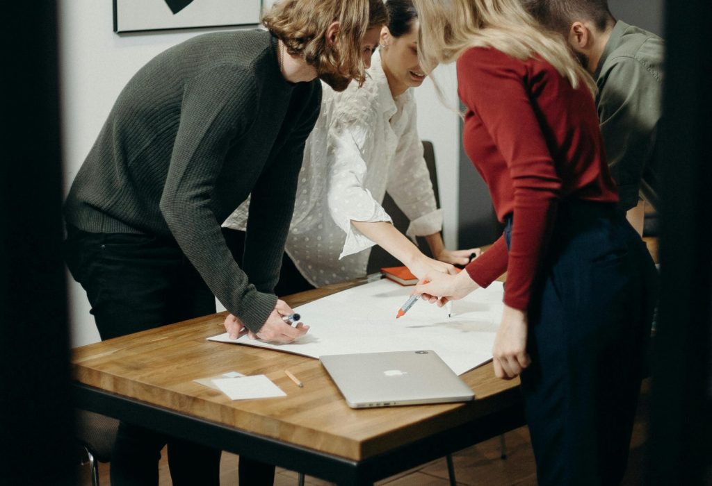 Group of diverse professionals brainstorming ideas in a stylish modern office space.