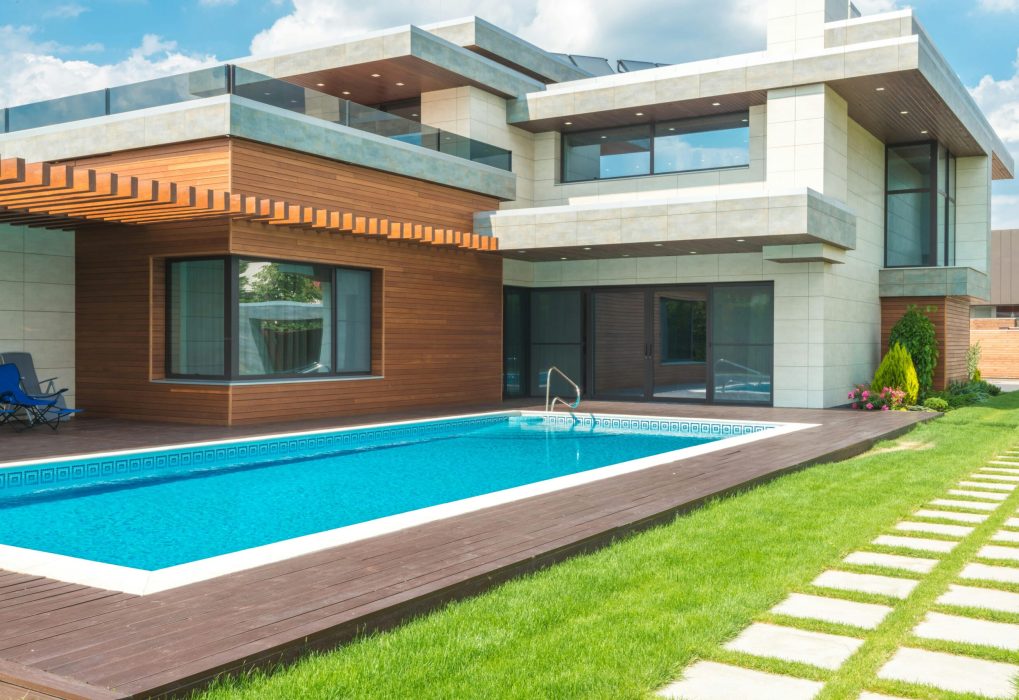 A stunning modern house with a spacious pool and green garden, ideal for relaxation.